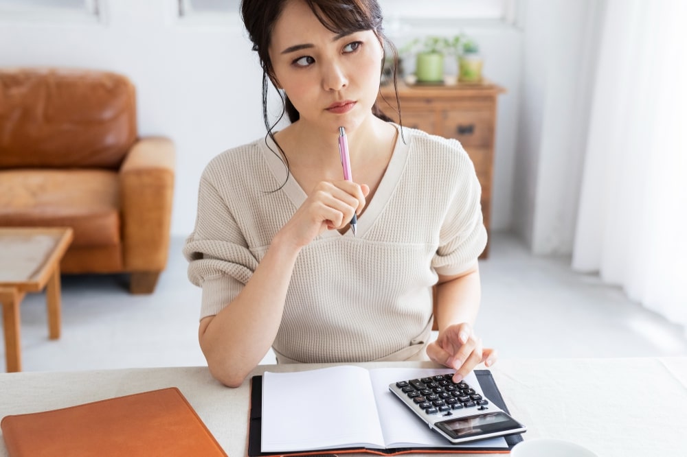 電卓を使って計算する女性